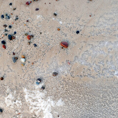 multicolored sea pebble on iced sand