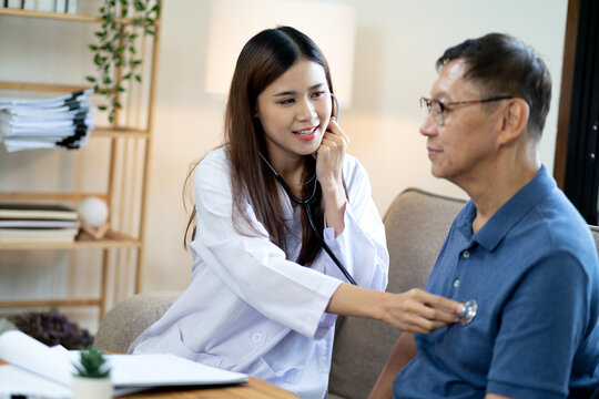 Asian Young Doctor Woman Using Heart Stethoscope Visiting Patients At Home