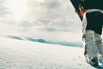 Snowboarder dressed in a full protective gear for extreme freeride snowboarding posing with a...