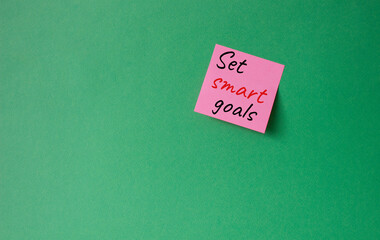 Set smart goals symbol. Concept words Set smart goals on pink steaky note. Beautiful green background. Business and Set smart goals concept. Copy space.