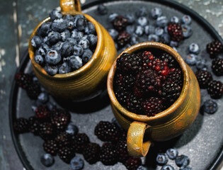 Guatemalan artisan jars filled with red fruits, blueberries and blackberries