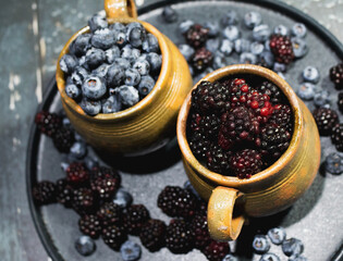 Guatemalan artisan jars filled with red fruits, blueberries and blackberries