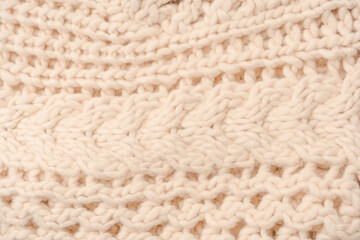 A fragment of beige knitted fabric, knitted from white sheep wool.