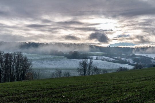 orage s'abattant sur une vall&eacute;e avec les champs recouverts d'une fine pellicule de neige par une froide journ&eacute;e hivernale proche d'issoire dans le puy de d&ocirc;me