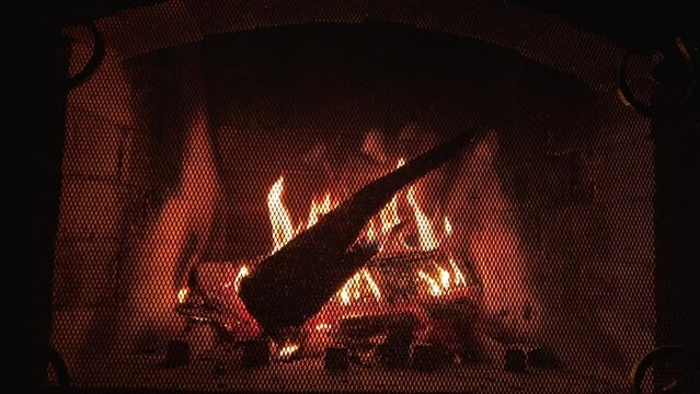 Burning firewood in fire-box of fireplace in country cottage. Rustic cooking oven with burning logs. 