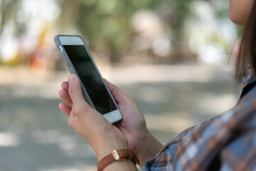 Close up hand of technology in use . Businesswoman typing on smart phone with hand finger touch screen, texting, chatting or social media on street