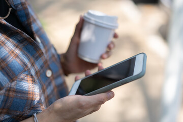 Close up hand of technology in use . Businesswoman typing on smart phone with hand finger touch screen, texting, chatting or social media on street