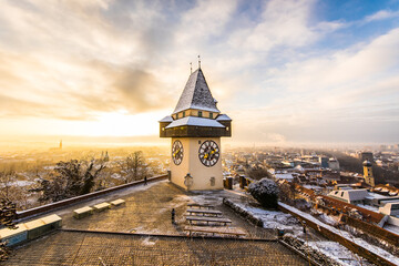 Sunrise at the Schloßberg landmark in Graz, Austria with the iconic clocktower and a dramatic sky