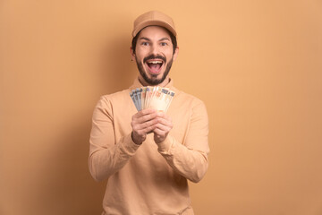 joyful bearded man with money from Brazil in beige background. financial, profit, credit, purchase,...