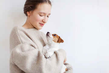 Happy young woman with embraces puppy dog