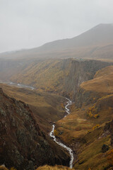 Photo of the gorge with mount river in it in Autumn foggy and cloudy day. Photo taken on Djily-Su road, it's popular tourist place in Kabardino-Balkaria, Russia