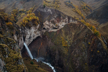 Photo of the waterfall named Kyzyl-Su that falls in the canyon from the cleft of rocks. Photo taken on Djily-Su road, it's popular tourist place in Kabardino-Balkaria, Russia