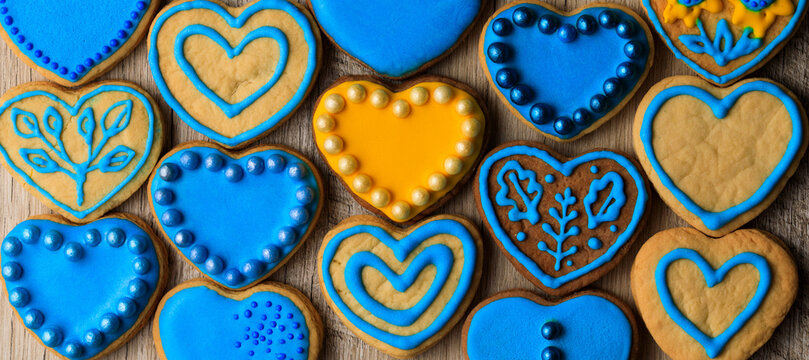 Pattern made of many heart shaped yellow and blue decorated cookies