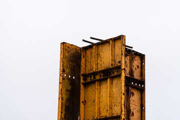 Steel formworks and reinforcing bars for pillars ready for concrete pouring. Yellow color