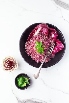 Risotto with radicchio, winter Nord Italy dish. Radicchio cicory  (Radicchio rosso di Treviso, Veneto)  on the white table. Winter recipes from the north Italy