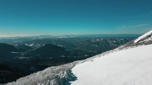 Taken from above with a drone of Mount Catria in the province of Pesaro Urbino. The mountain is covered with a lot of fresh snow and the trees are full of snow and ice