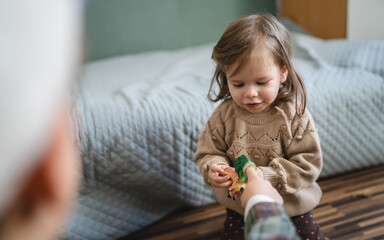 small caucasian girl toddler child play with finger puppets at home