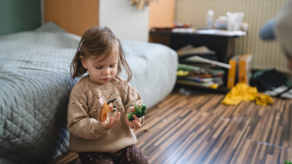 small caucasian girl toddler child play with finger puppets at home