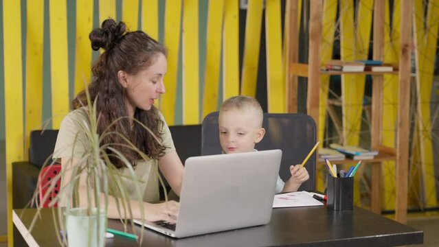Woman working at home and looking after son