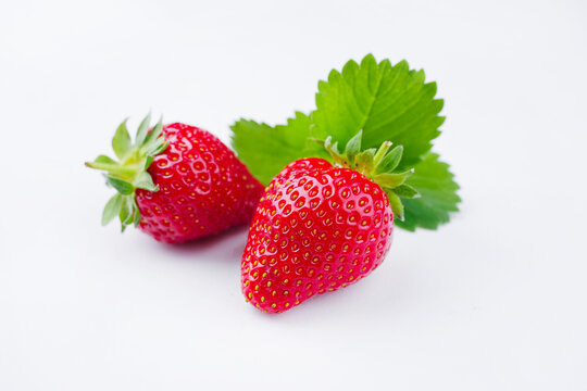 Reife rote Erdbeeren aus biologischem Anbau angeboten als close-up auf einem wei&szlig;en Board mit Textfreiraum 