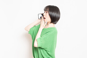 スマホを使いながら驚いている若い女性