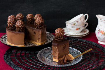 Tarta fría de chocolate y famosos bombones cubiertos de chocolate y avellanas troceadas, con una avellana entera en el interior