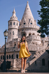 Fototapeta premium Young tourist woman in Budapest, Hungary. Beautiful girl visiting Fisherman's Bastion in the Castle District of Budapest, Hungary