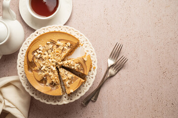 Caramel cheesecake served with cup of tea, top view. Copy space