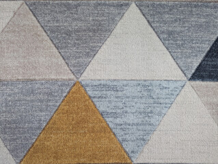 carpet, which consists of blue, gray, white and orange triangles