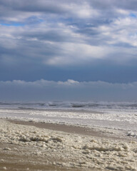 Sea foam along the coast from rough waves after a big storm. Long Island New York