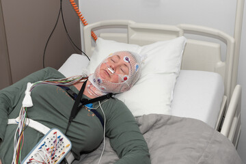 Middle aged woman measuring brain waves, examining polysomnography in sleep lab - obrazy, fototapety, plakaty
