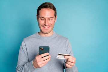 Cheerful man with smartphone and credit card