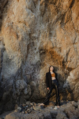 Model standing near the rock. Mika Nakano - obrazy, fototapety, plakaty