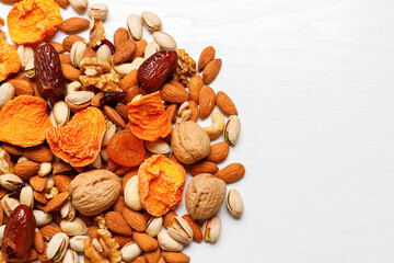 Dried fruits and nuts, branch on white background . Concept of the Jewish holiday Tu Bishvat. Copy space