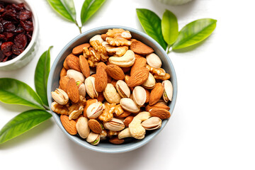 Dried fruits and nuts, branch with young green leaves on white background . Concept of the Jewish holiday Tu Bishvat. Copy space