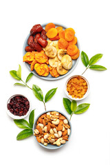 Dried fruits and nuts, branch with young green leaves on white background . Concept of the Jewish holiday Tu Bishvat. Copy space