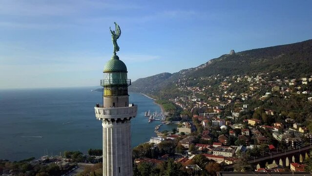 aerial drone shot of trieste gulf with vittoria lighthouse in foreground