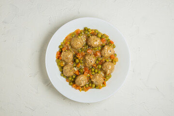 Plate of meatballs in gravy with vegetbales