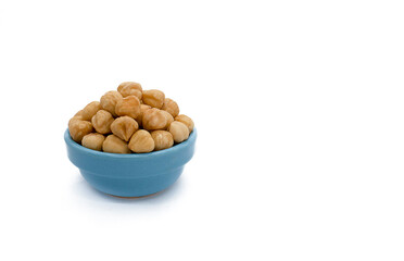 hazelnuts photographed in a blue bowl, close up, isolated