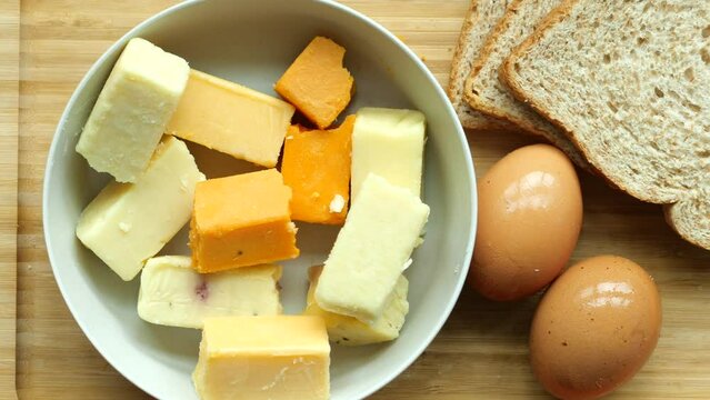 Cheese cubes green, yellow and red color on chopping board 