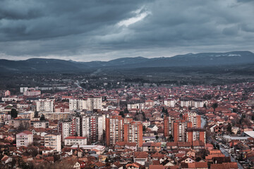 Dark, moody, cloudy sky on a winter day over cityscape with orange brick buildings