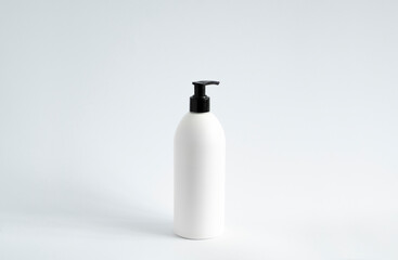 White blank plastic bottle with black dispenser pump for gel, liquid soap, lotion, cream, shampoo on white background. Cosmetics.