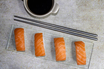 Salmon sushi with soy sauce on a glass base