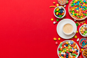 Coffee cup with chocolates and colored candy. Top view on table background with copy space