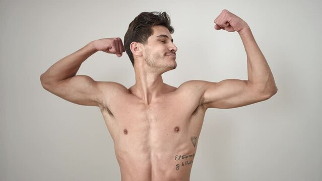 Young hispanic man smiling confident doing strong gesture with arms over isolated white background