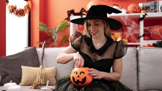 Young blonde woman having halloween party eating candy sweet at home