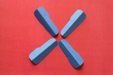 four cut blue construction paper shapes on red