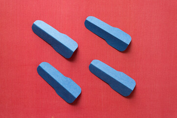 four isolated cut blue construction paper shapes on red