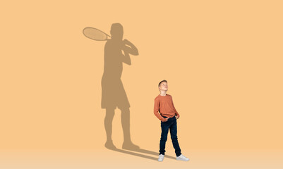 Little redhead boy and shadow of adult tennis player behind