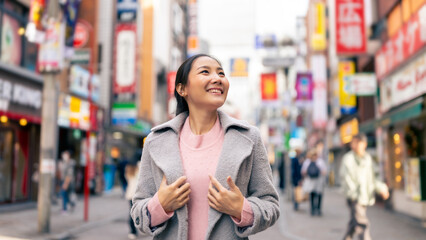 Asian woman looking modern building cityscape during travel at Shibuya district, Tokyo city, Japan....
